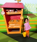 Little girl hold an egg in front of a chicken coop display