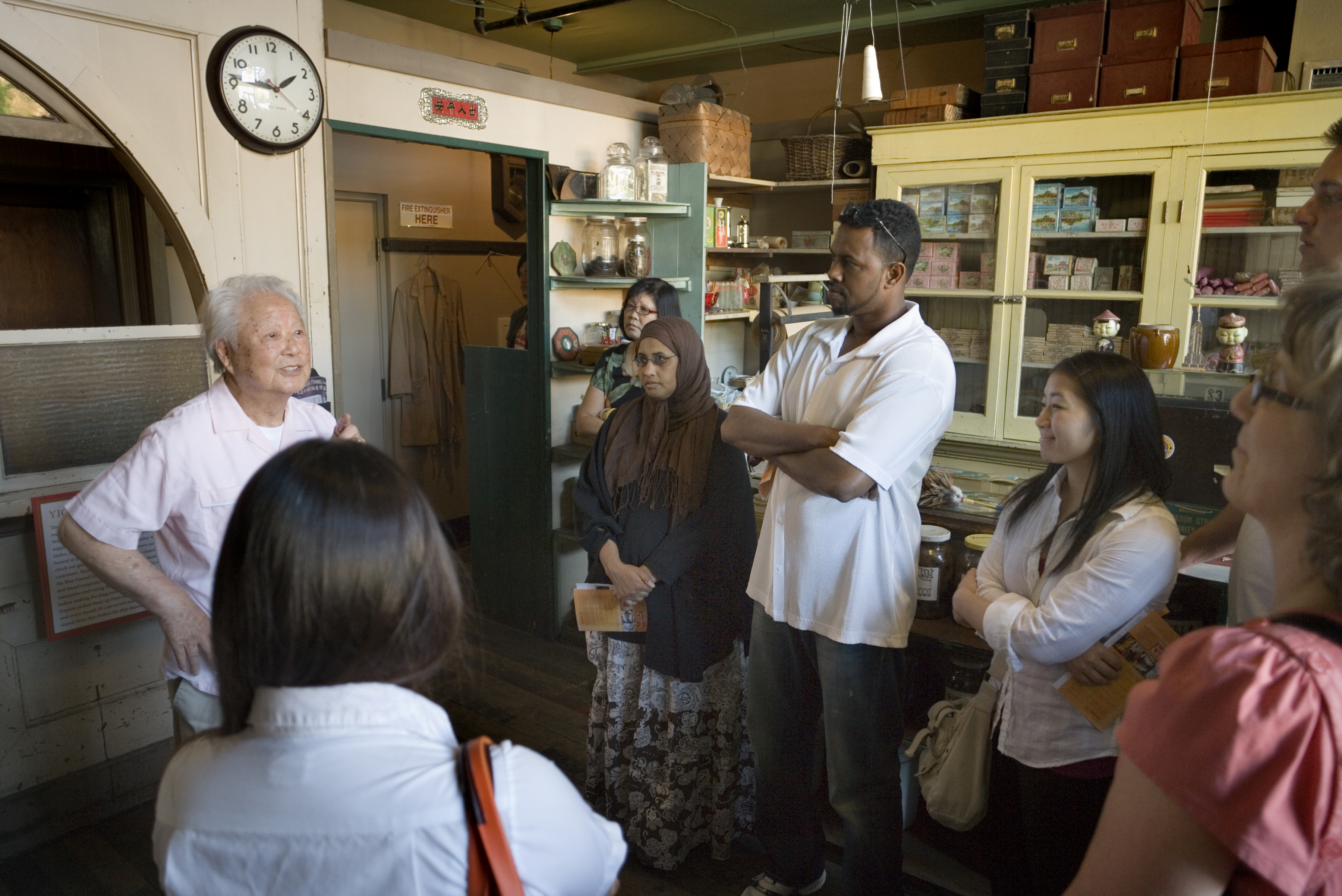 A senior man talks to a tour group at the Wing Luke Museum.