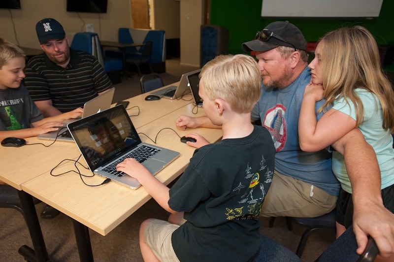 Teens at laptop with parents