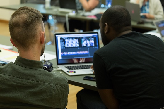 Two men sitting with laptop