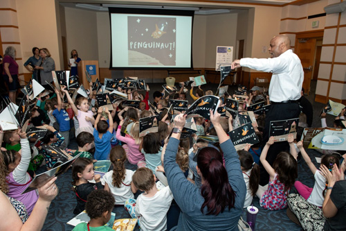 Denver Mayor giving reading books to children.