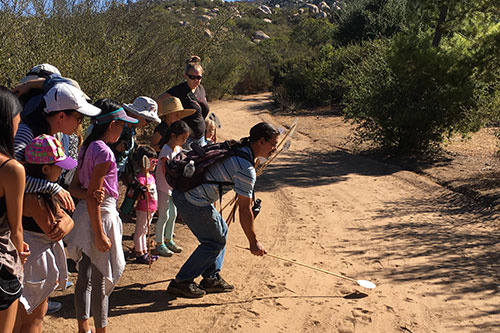 Participants on a nature walk with Barona Cultural Center & Museum learn about tracking animals and how Kumeyaay/Diegueño ancestors hunted.