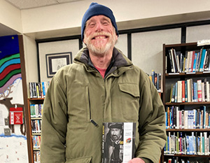 Library visitor holding book.