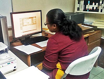 woman at a computer station digitizing document