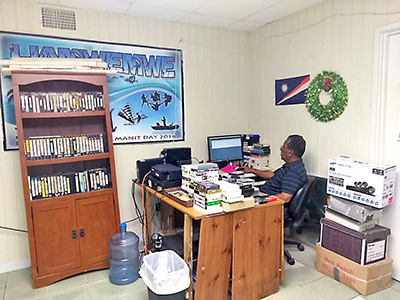 man at a computer station with VHS tapes