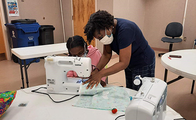 Makerspaces participants engage in sewing and embroidery activities.