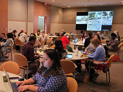 room full of participants seated at tables.