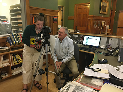 two people using laptop to setup video camera and transcript.