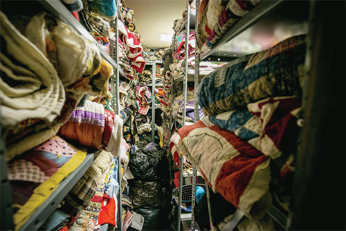 Quilts stacked on racks for conservation and protective storage.