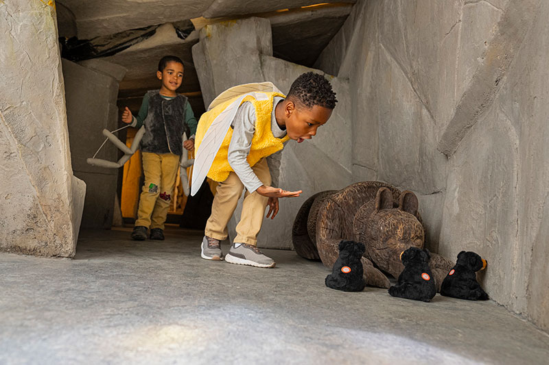 two boys interacting with museum exhibit