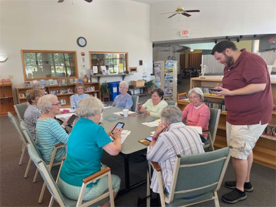 People sitting at table listening to instructor.
