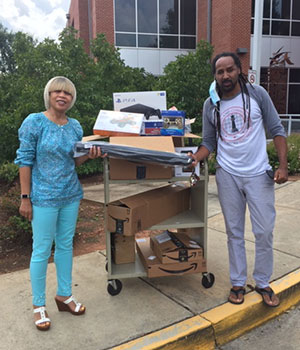 Valerie Bell and Lemuel Roche giving Chess & Community supplies to run their programs virtually.