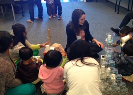 Denver Public Library volunteer works with participants during an in-library migrant education activity sponsored by Project SPELL.