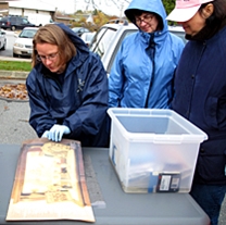 A staff member handles a collection item at a workshop.
