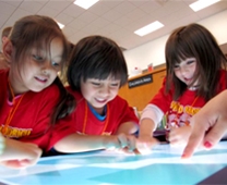 three children use a smart table