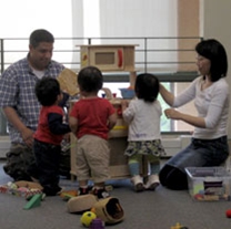 two adults and three early learners play together 