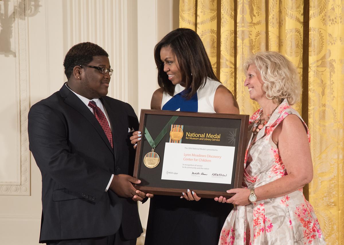 First Lady Michelle Obama presents the award to community member Brandon Spann and Lynn Meadows Discovery Center for Children Executive Director, Cindy DeFrances. 