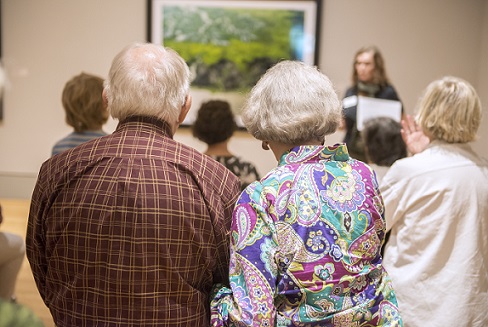 A couple sit and view exhibit