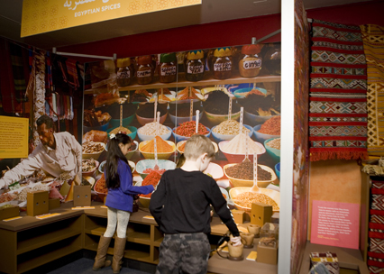 Families learn about spices from a children’s museum educator working off a discovery cart in the America to Zanzibar: Muslim Cultures Near and Far exhibit.  Photo credit: Prince V. Baron