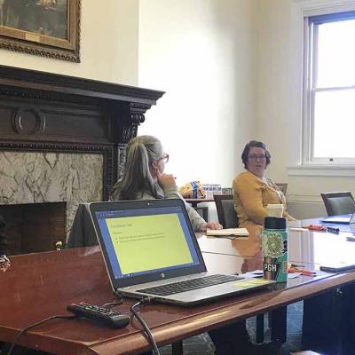 People sitting at a conference table inside Carnegie Library of Pittsburgh building.