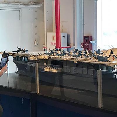 A Museum Educator explores the museum using a tablet to communicate with students in real time for a remote learning session.