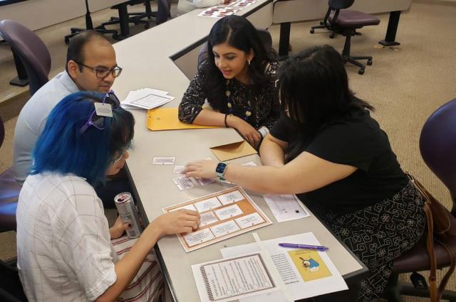 A group of library professionals seated at a table and working together.