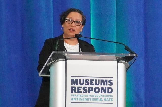 Deputy Director of Museum Services Laura Huerta Migus standing behind podium.