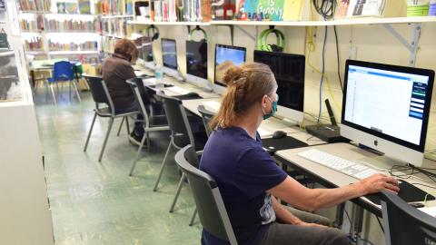 Woman seated in front of library computer station.