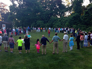 Library visitors stand in circle formation outdoors.