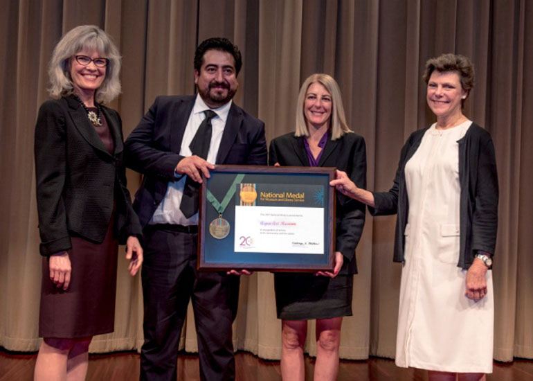 2017 National Medal recipient on stage with IMLS director and guest speaker